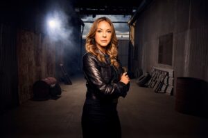 Eva LaRue standing near warehouse